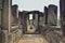 A dilapidated stone corridor at the top of the temple. Doorways, windows, columns are damaged by time.