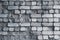 Dilapidated white brick wall, grunge background. Gray brick wall pattern, weathered texture. Grey stone concrete wall. Old cracked