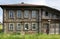 Dilapidated wooden residential house with carved facade. Village of Visim, Russia