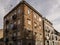 Dilapidated worn classic apartment building facade in city street