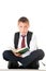 A diligent boy reads a book and prepares for exams and tests. Schoolboy teenager dressed in a school uniform. Isolated white