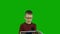 Diligent Caucasian boy in glasses holds a book in his hands, the child learns to read. .Green screen