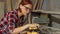 Diligent female carpenter sanding wood at the workshop