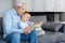 Diligent handsome granddad reading for his grandson