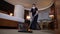 Diligent housemaid vacuuming carpet in hotel room