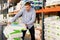 Diligent male buyer storing fertilizer bags on trolley in hardware store