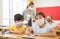 Diligent tween girl in protective mask studying in school