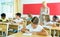 Diligent tween girl studying with classmates in elementary school