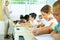 Diligent tween girl studying with classmates in elementary school