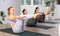 Diligent women practicing upward boat pose of yoga in light fitness room