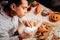 Diligent young baker feeling joyful while decorating pastry