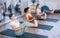 Diligent young women practicing upward boat pose of yoga on mat in fitness room