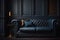 In a dim room, a leather sofa sits against a backdrop of empty, dark blue walls