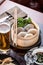 Dim Sum in Bamboo Steamed Bowl anf glass of beer on wooden table