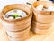 Dim sum , this is a popular Chinese food which were steamed. They are in the small bamboo basket. In the picture, there are six