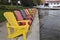 Diminishing perspective view of multi coloured Muskoka Chairs in the lake front of the tourist resort