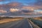 Diminishing road amidst volcanic landscape against dramatic sky during sunset