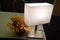 A dimly lit room by a white square simple table desk light