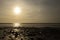 Dinas Dinlle beach with the sun setting reflected in the sea.  Beach holiday concept