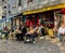 Diners lounge in the sun at the cafe Au Petit Montmartre in the Place des Abbesses, Paris