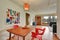 Dining area interior with red chairs and apples on the table.