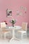 Dining room interior with flowers decorative plates pink wall an