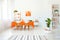 Dining room in vivid color. Orange tablecloth on table with white chairs