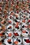 Dining table covered with cups of delicious honey yogurt topped with fruit and granola