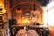 Dining table of Italian restaurant decorated with brick and photo frames in warm light that created cozy atmosphere