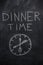 Dinner time text with clock on black chalkboard