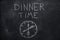 Dinner time text with clock on black chalkboard