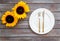 Dinning table decorated with sunflower, dark wooden background top-down