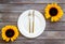 Dinning table decorated with sunflower, dark wooden background top-down
