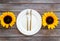 Dinning table decorated with sunflower, dark wooden background top-down