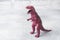 Dinosaur on a gray background. Plastic rubber toy. Selective focus