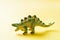 Dinosaur on a yellow background. Plastic rubber toy. Selective focus