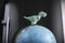 Dinosaurs toy on globe model on dark background