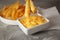 Dipping tasty fries into cheese sauce in bowl