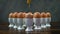 Dipping a toast soldier into a boiled egg at the front of a group of eggs in white egg cups on a wooden table