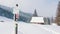 Direction signs on mountain covered in snow and evergreen forest