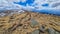 Directional path mark with Austrian flag painted on a rock on remote alpine dry meadow near Ladinger Spitze, Saualpe, Austria