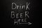 Directional sidewalk chalkboard sign reading drink beer here