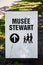 Directional signboard of Stewart Museum with a family drawing on it on St. Helen`s island, Montreal, Quebec, Canada