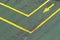 Directional traffic yellow arrow on a green tarmac texture floor.