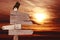 Directional wooden arrows in sunset background