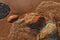 Directly Above Shot of Small Waves Rolling into Beach Dotted with Colorful Rocks and Boulders