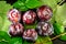 Directly above view of ripe and fresh purple plums close up on green leaves for washing