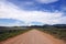 Dirt Desert Road and Blue cloudy Sky