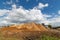 Dirt mound on a background of blue sky with white clouds