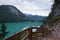 Dirt path to staircase runs along the Braies Lake under a cloudy sky